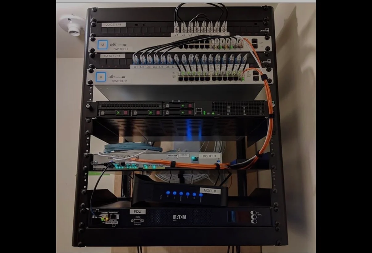 Installed network rack with switches, patch panels, modem, router, and organized cabling