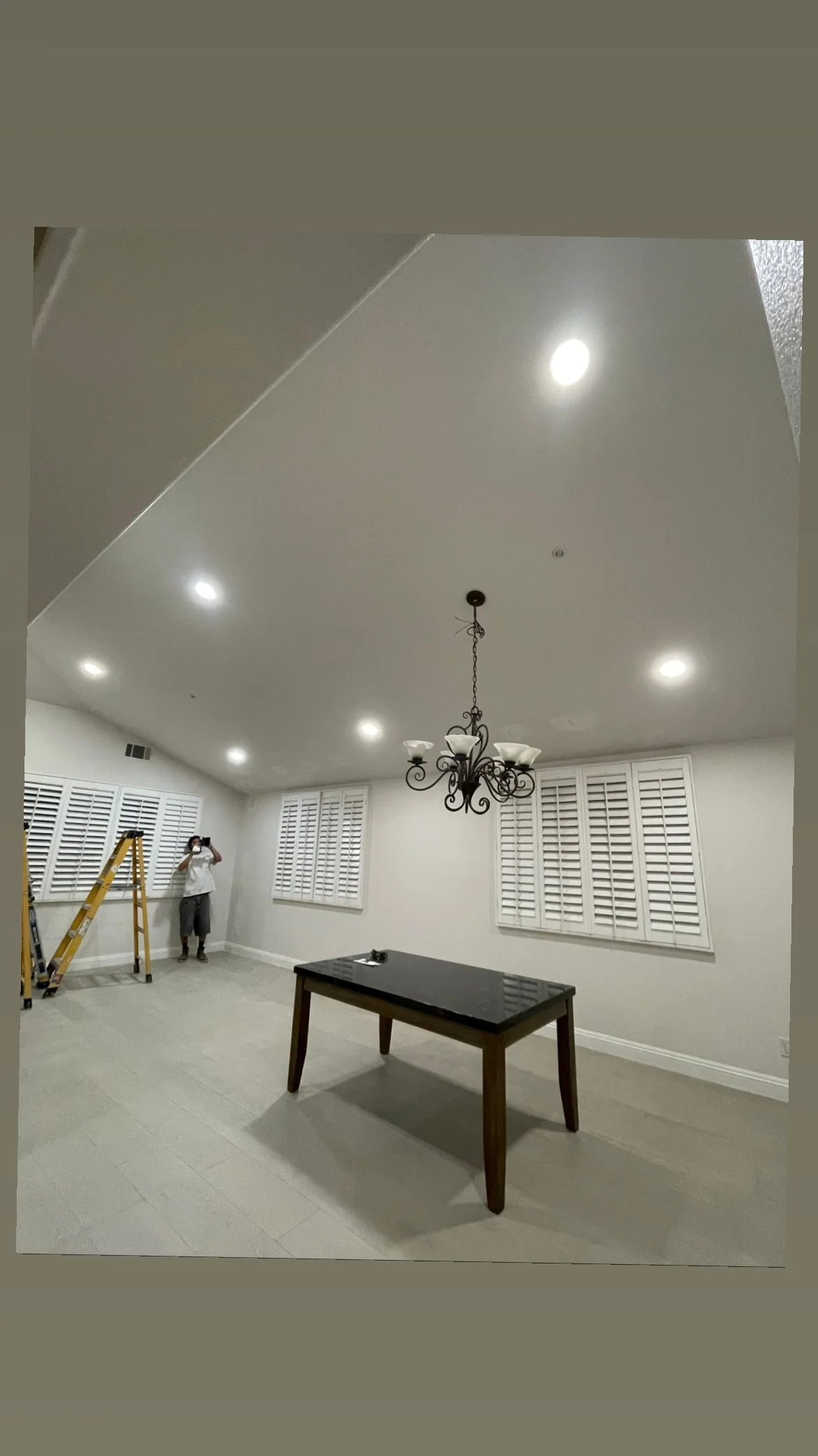 Recessed ceiling lights installed in vaulted room with white walls and shutters