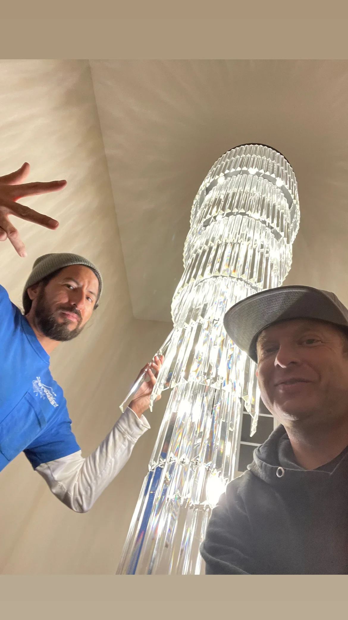 Two technicians installing organized structured wiring bundles in ceiling space