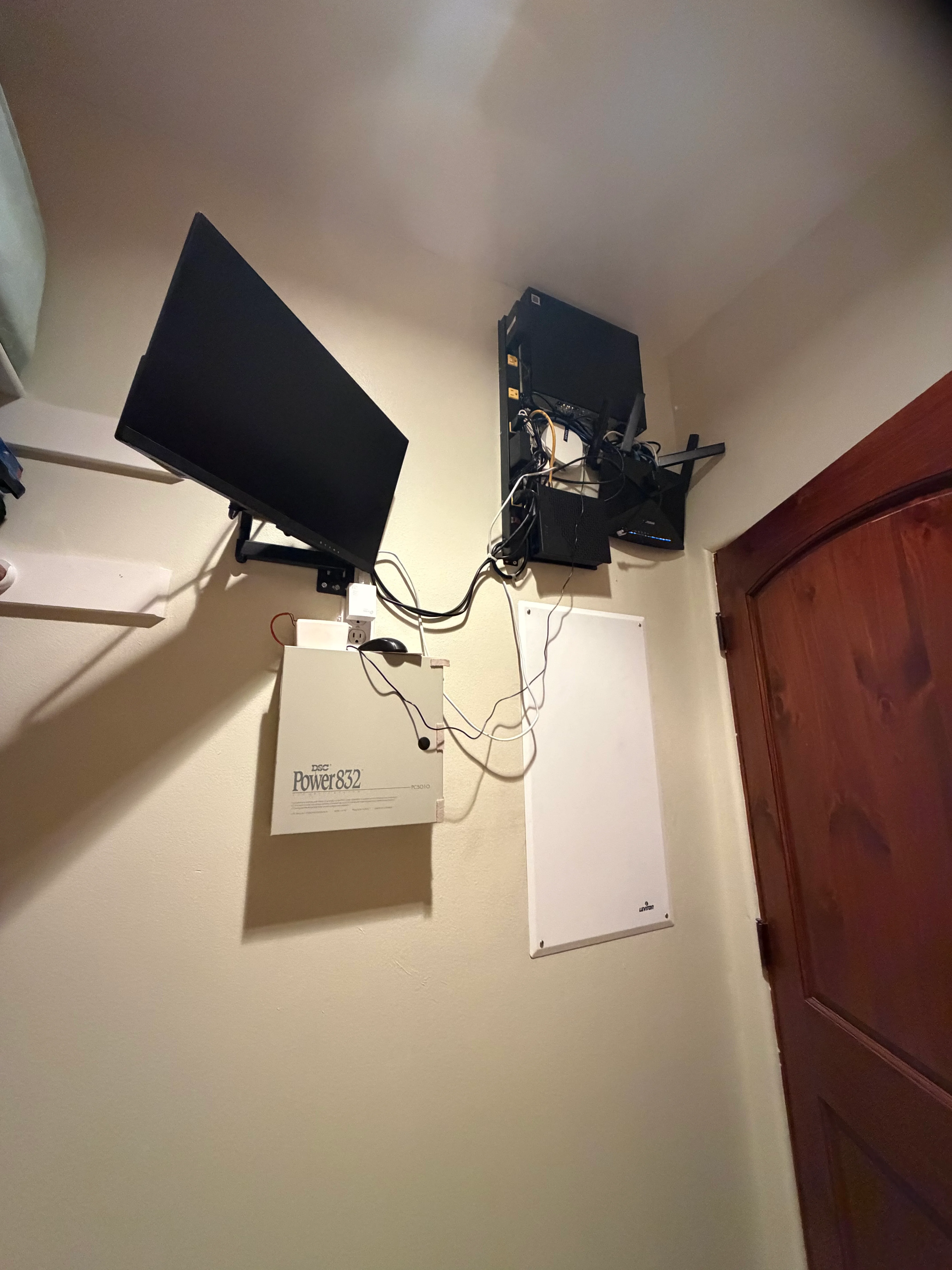 Dual monitors mounted on wall with organized cabling and Power832 distribution unit
